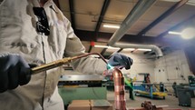 Pipefitter using an oxyacetylene torch brazing copper pipe