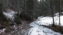 Narrow Frozen River In The Winter Forest - panning shot