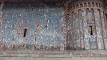  Handheld shot of Frescoes On The Exterior Of Voronet Monastery Church In Romania.
