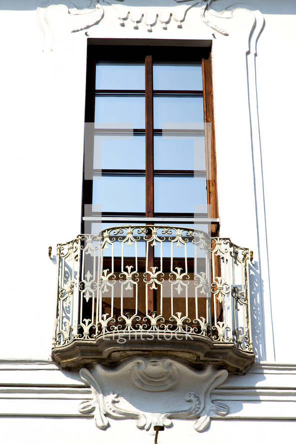 A tall window with an iron balcony.