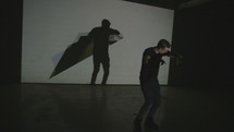 a man rapping in front of a projector 