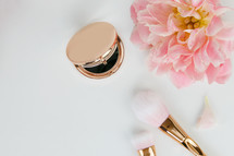 pink spring flowers, gold makeup brush, and gold hand mirror 