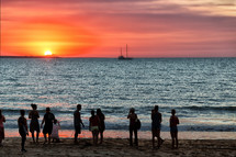 people on the bay of Darwin watching the sunset 