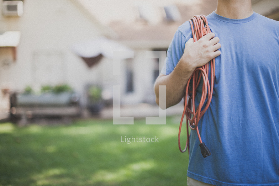 man carrying an extension cord