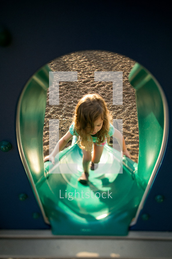 Girl climbing playground slide
