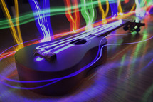 A ukelele surrounded with neon lights