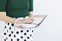 a woman writing in a planner 