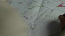 Close-up of Man’s hands drawing lines on the Large Format Paper at Modern Office. Architect using Ruler and Pencil to make Blueprints on Paper
