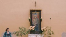 Girl praying to Mother Mary in the streets of Italy