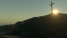 Time lapse of the sun rising behind a single cross on a hill.