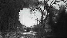 Old narrow gauge steam train in the countryside filmed in B/W.
