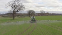 Tractor Spraying a Controversial Glyphosate Herbicide on Agricultural Land