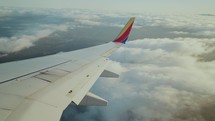 Airplane wing flying through clouds