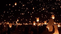 Lanterns released into night sky with community of people