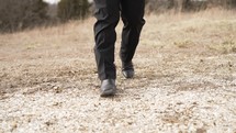 Walking in black cowboy boots over gravel 