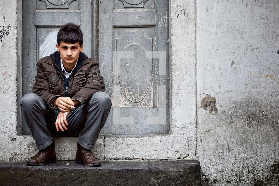 Turkish teen sitting on a door step