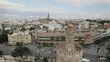 Tower of Gold or Torre del Oro and Cathedral in background, Seville in Spain. Aerial reverse ascending