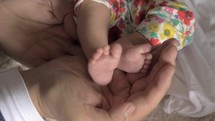 Dad holding baby feet in hands