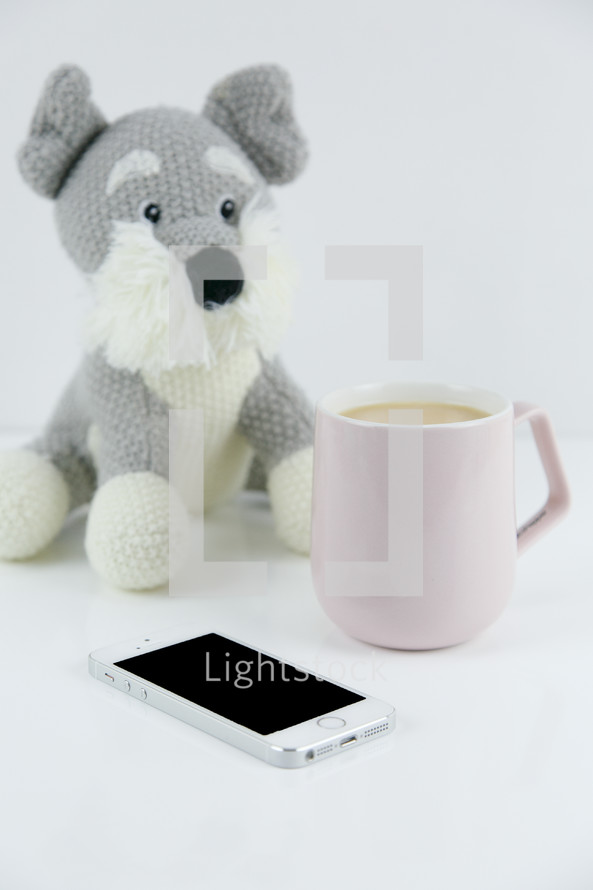 stuffed dog, coffee mug, and iPhone 