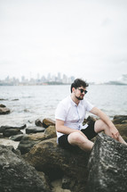 a man sitting on a rocky shore in Australia 