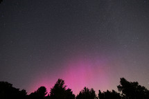 Night sky with some pillars of pink Aurora Borealis 