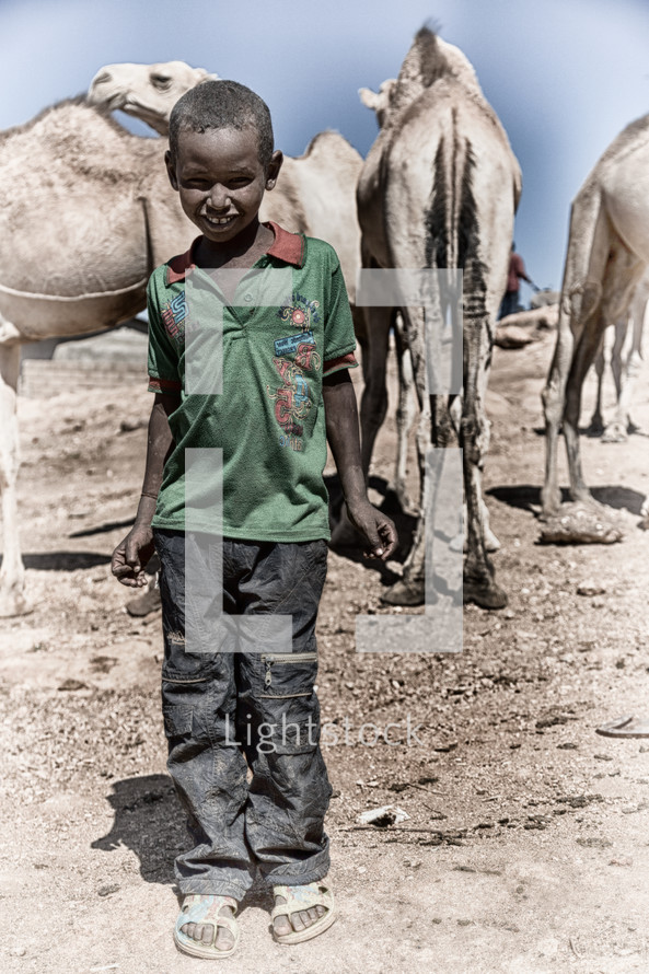 child near camels in Ethiopia 
