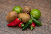 Chili, Lime and Kiwi Fruit on a Wooden Table