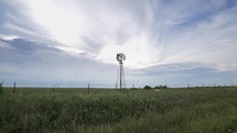Windmill in farmland prairie grass in cinematic slow motion.
