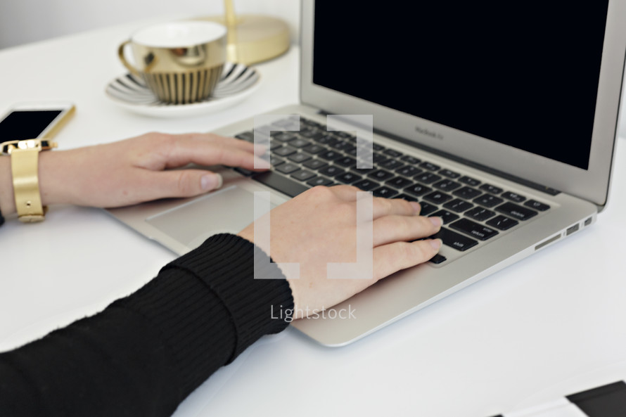 a woman typing on a laptop computer 