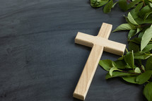 cross and green leaves on a black background 