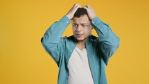 Worried man doing panic despair gesture, like no, I forgot. Disappointed guy feeling sorrow, regret, drama, failure, problems on yellow background. High quality 4k footage