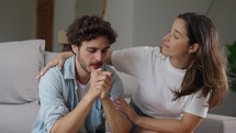 Husband sit on couch feels upset by bad news about health, infertility, dismissal, loving wife hug him gives psychological support tell encouraging speech comforting beloved man. Care and love concept
