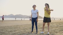 Two young cute women jogging at the beach to keep fit - Couple of female friends running together in the morning for their healthy
