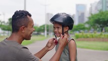 Daddy and boy child with bike, helmet and safety with teaching, celebration or motivation for goal. Father, son and bicycle outdoor in street with learning, helping hand and support
