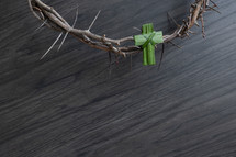 crown of thorns and palm cross on a gray wood background 