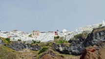 Famous whitewashed and colourful at the same time picturesque village of Oia built on a cliff, Santorini island, Cyclades, Greece