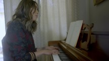 a woman playing a piano and singing