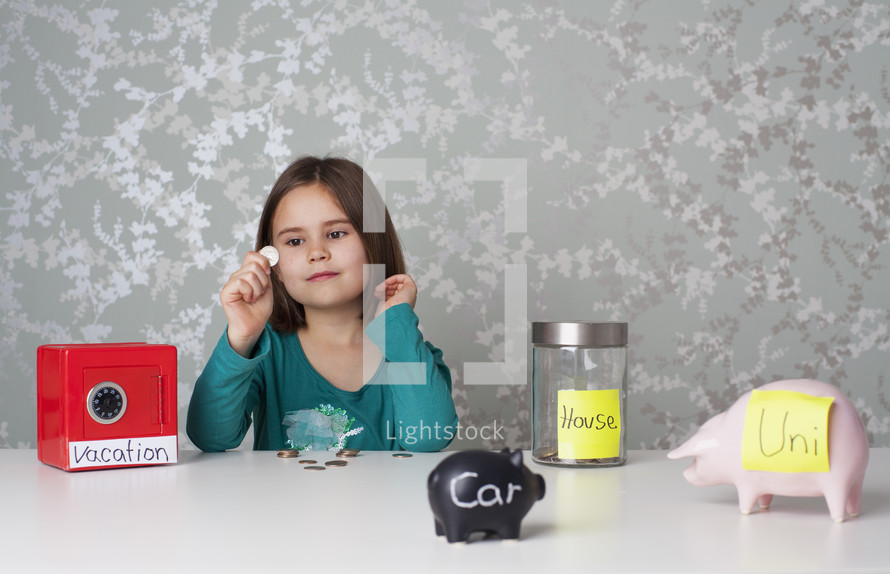 Girl surrounded by piggy banks and money boxes all with labels of big savings goals themes of finance future investing