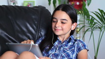 Preteen girl on tablet with ear buds
