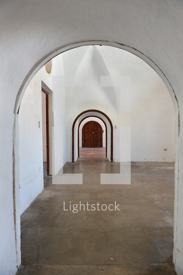 Archways in a home leading to a door.