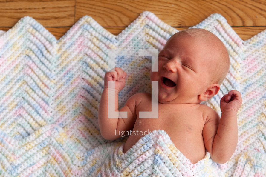 Newborn baby laying on a crochet blanket