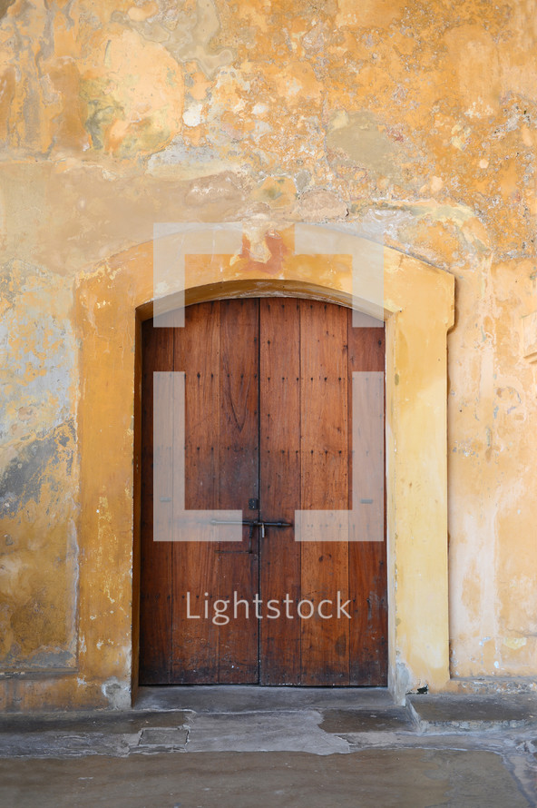 Vintage wooden door in a stucco building.