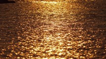 Dark water with golden sun path
