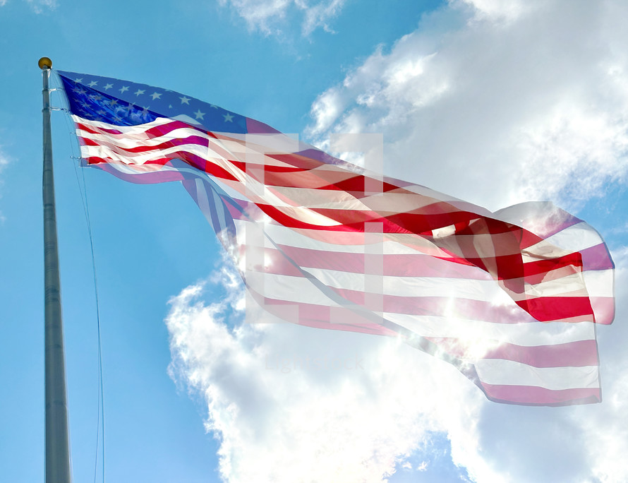 double exposure effect of US flag flying in from of bright beautiful sky
