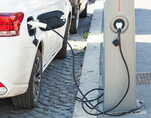 The electric car charger plugged in to the socket. The modern electric car charging the battery.