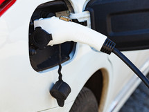 The electric car charger plugged in to the socket. The modern electric car charging the battery.