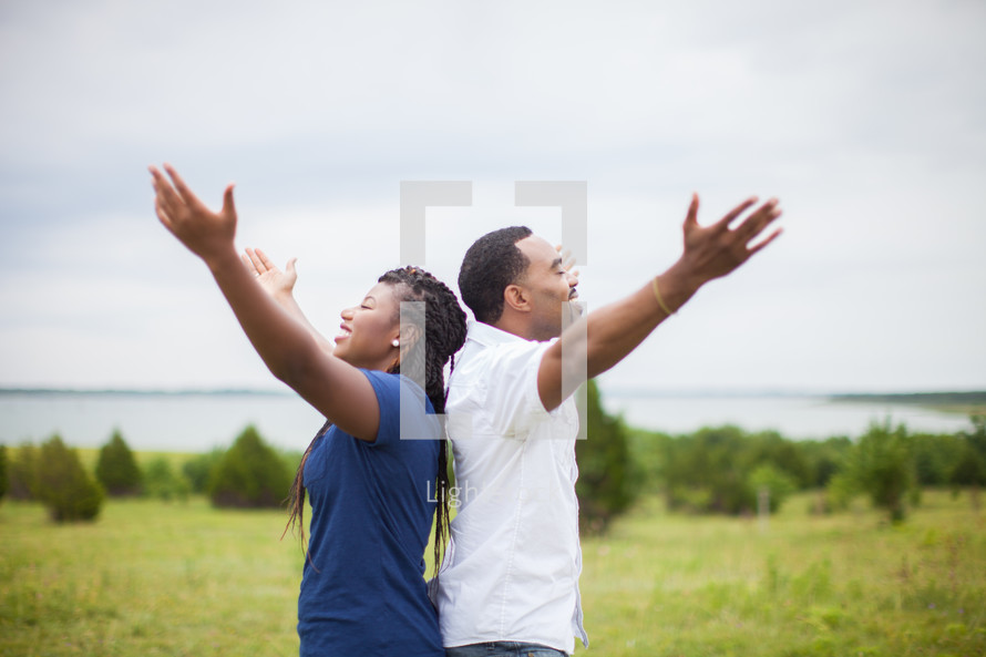 couple with raised hands praising God 