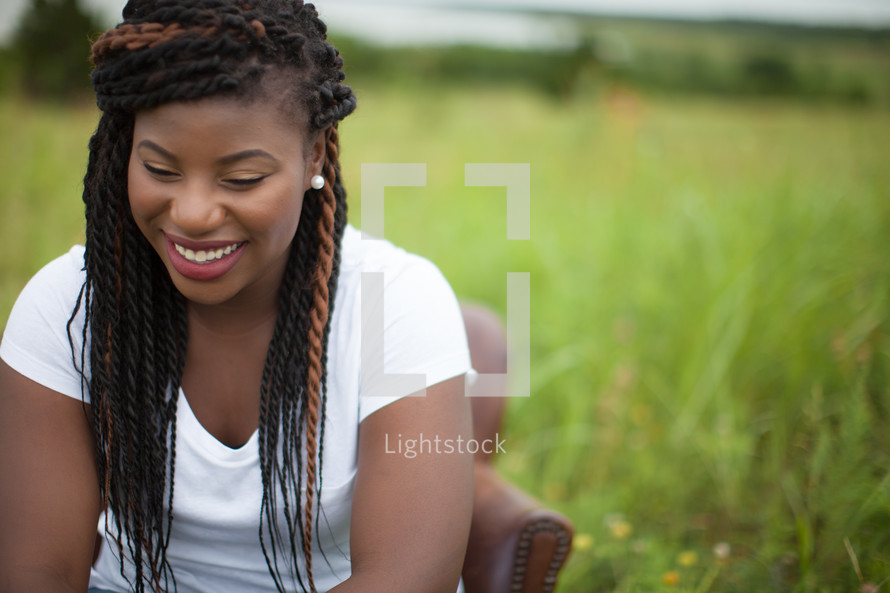smiling African-American woman sitting in a chair outdoors 