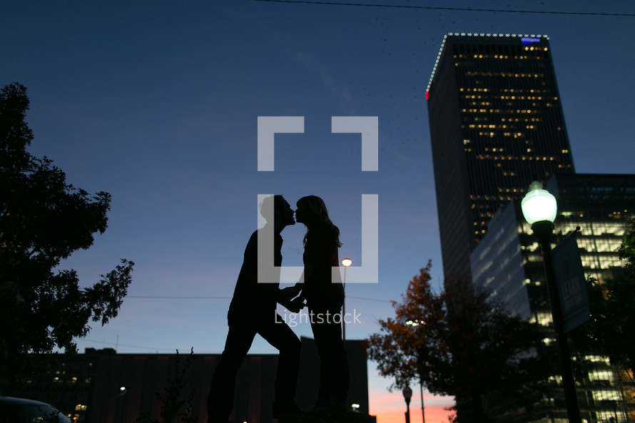 Couple kissing at sunset in the city