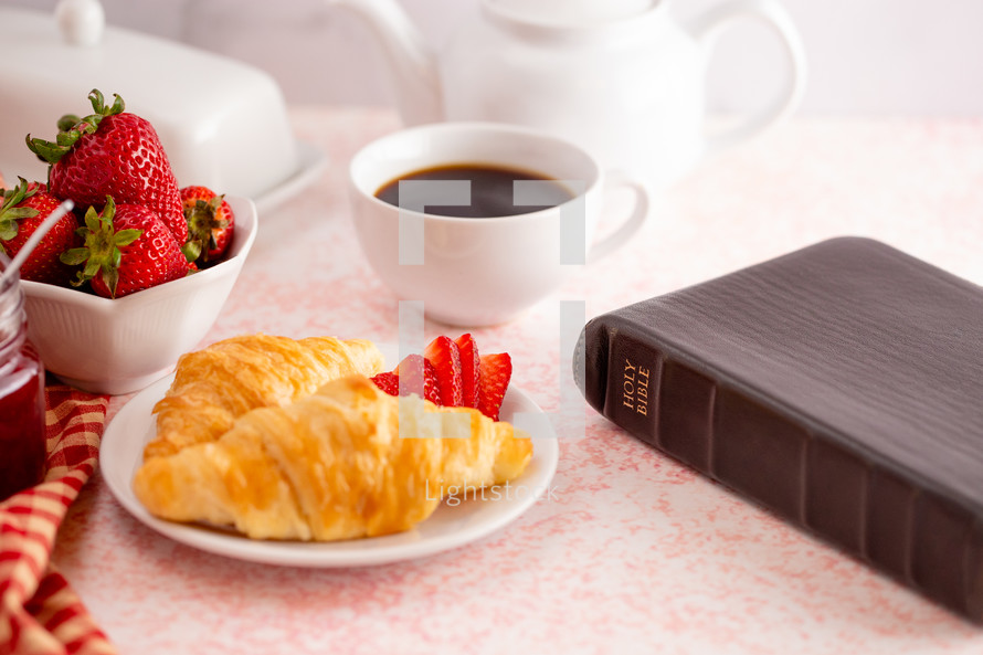 croissants and strawberries with a Bible 